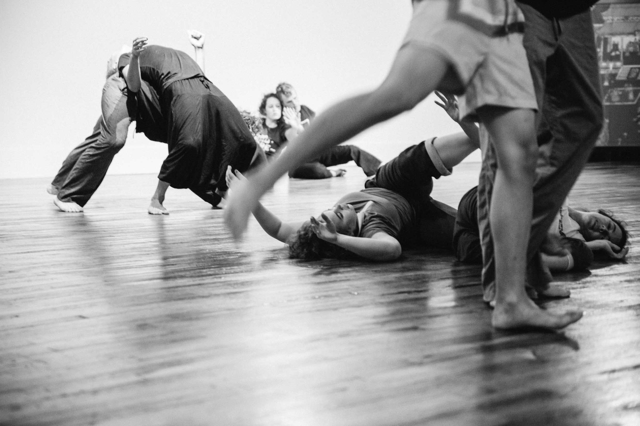 Several dancers in various positions in an open studio