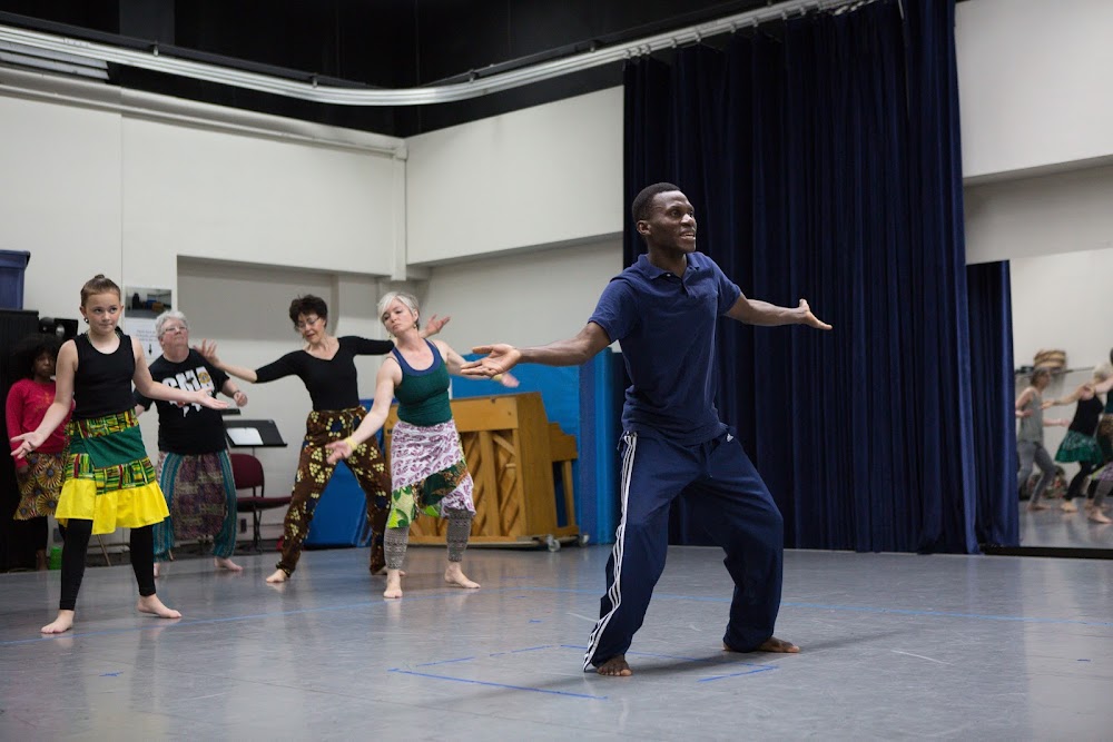 Sana Bangoura, a dark-skinned man from West Africa, teaches movement to class of students