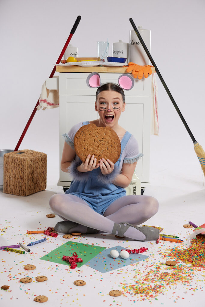 Dancer in mouse costume with large cookie.